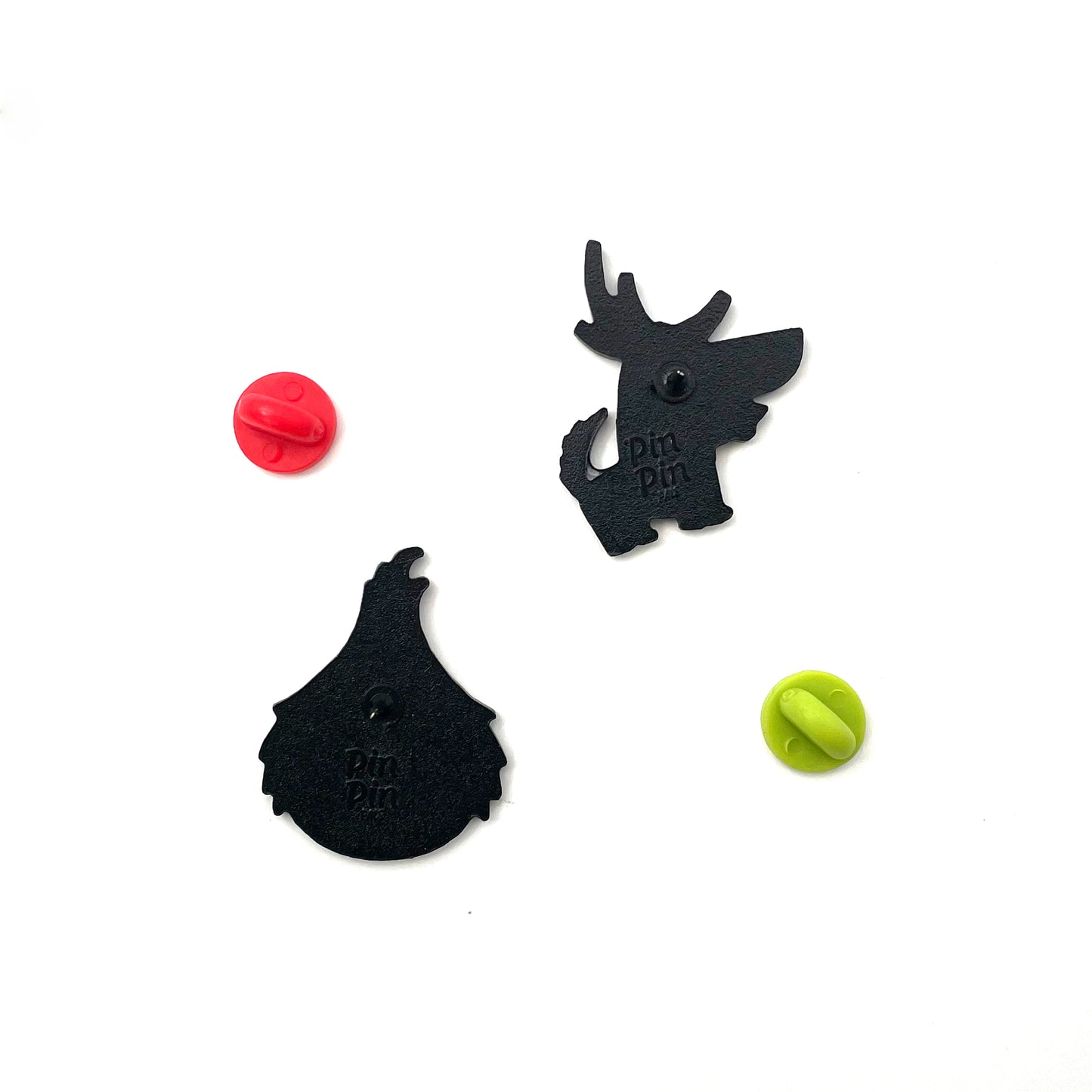 Backs of The Grinch and Max enamel pins with red and green rubber backings