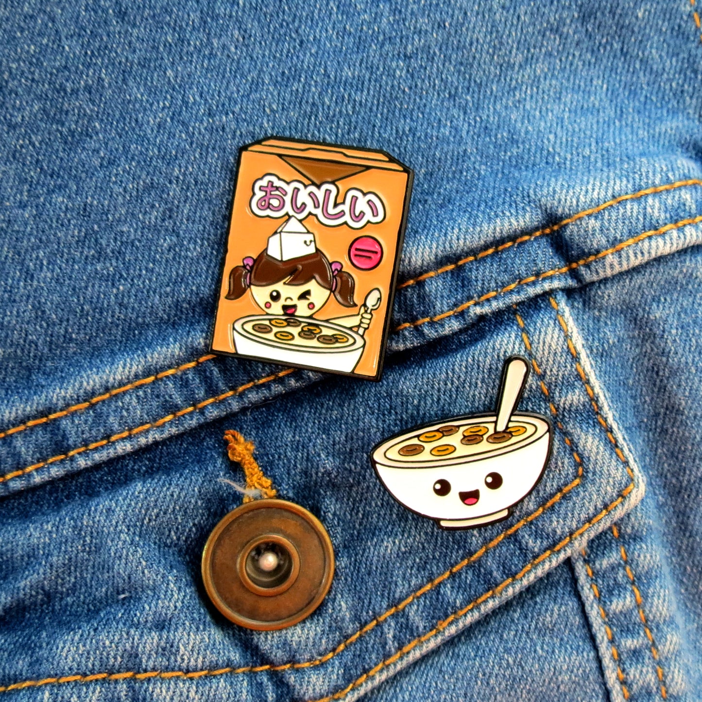 Cocoa Cereal Box and Cereal Bowl enamel pins on jean jacket pocket