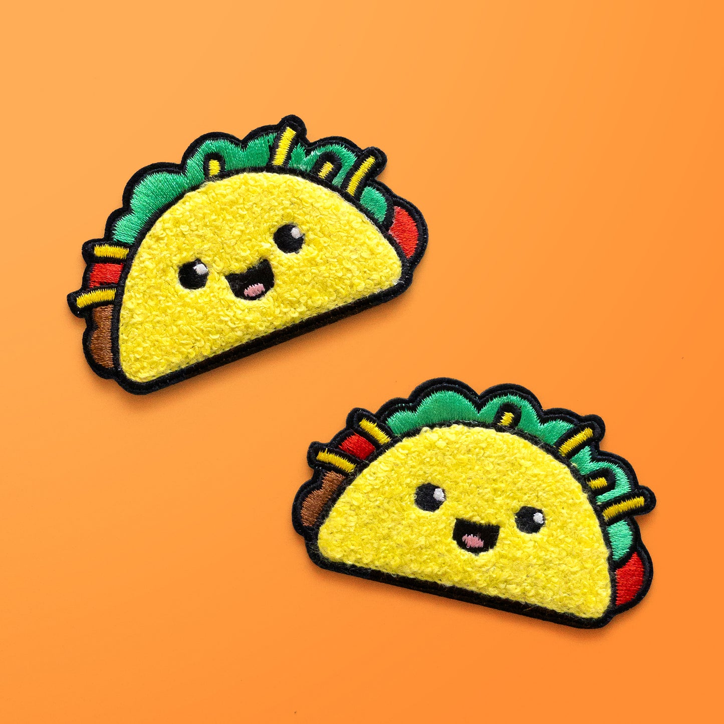 Two Taco iron on chenille patches on orange background