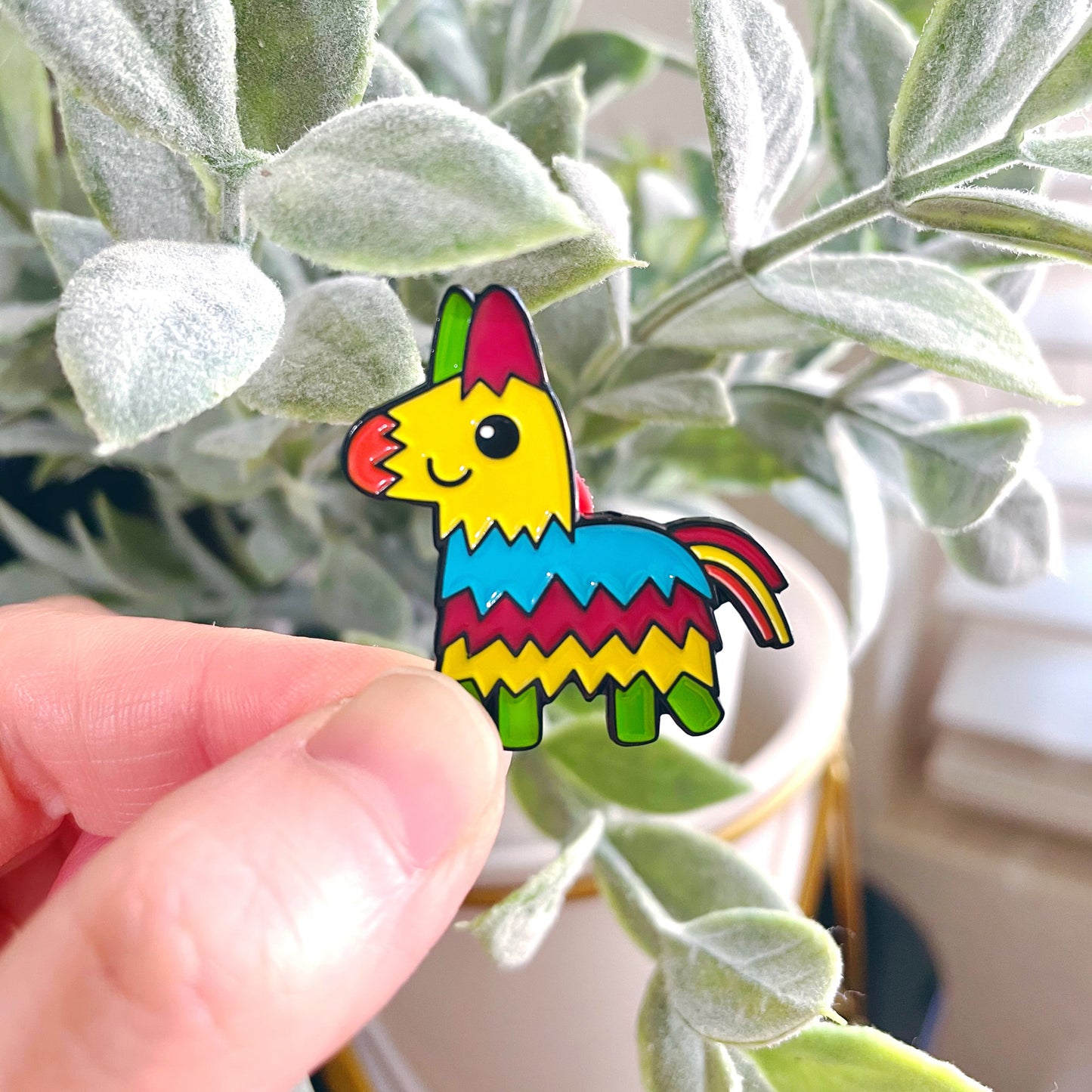 Pinata Enamel Pin with succulent in background