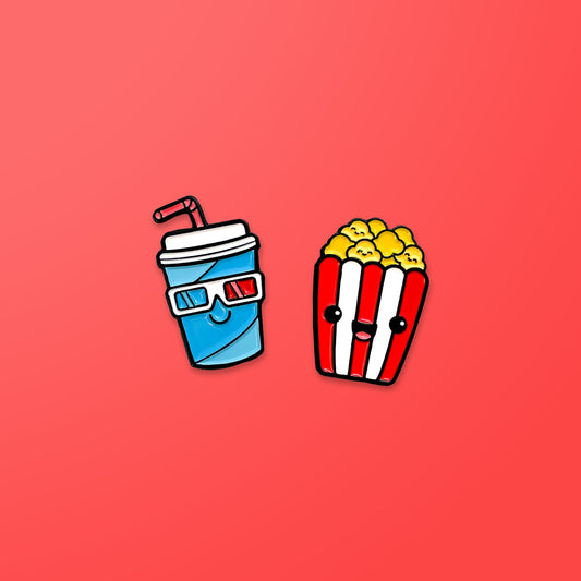Popcorn and Soda enamel pins on red background
