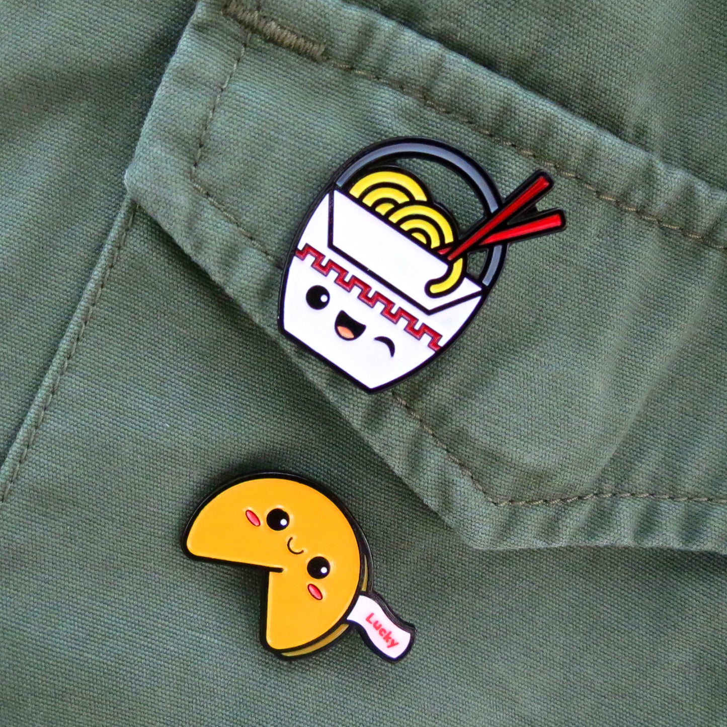 Chinese Takeout and Fortune Cookie enamel pins on olive green canvas jacket pocket