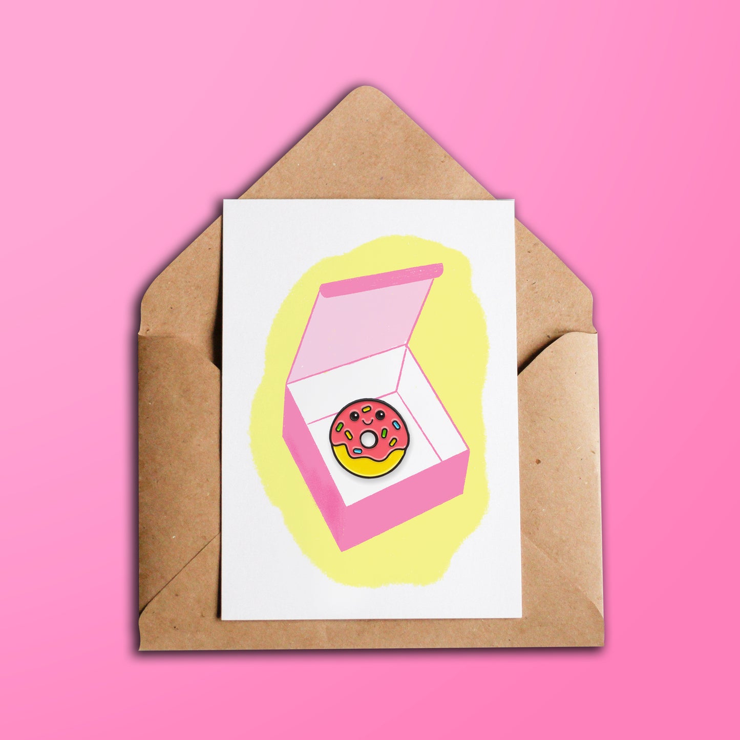 Happy Birthday Donut greeting card over kraft brown envelope on pink background